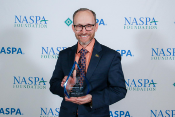 Christopher Lewis posing with his award