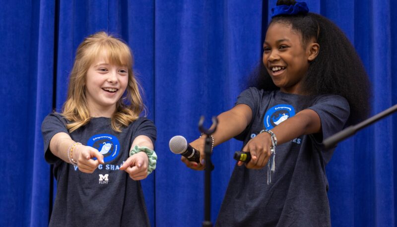 Two young girls on stage pitching their idea