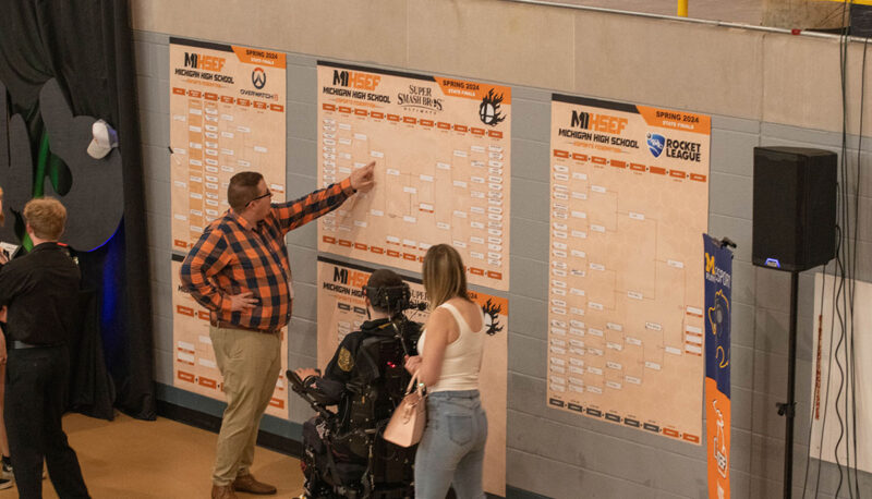 People reviewing the standings brackets on the wall