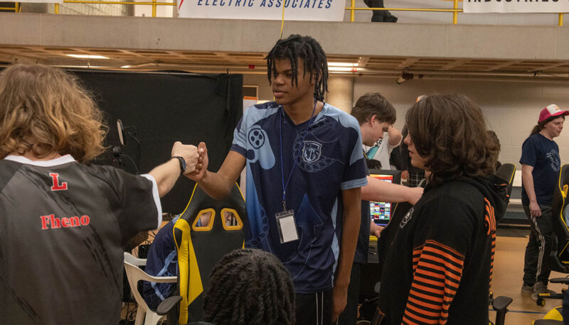 Two esports competitors giving a fist bump.