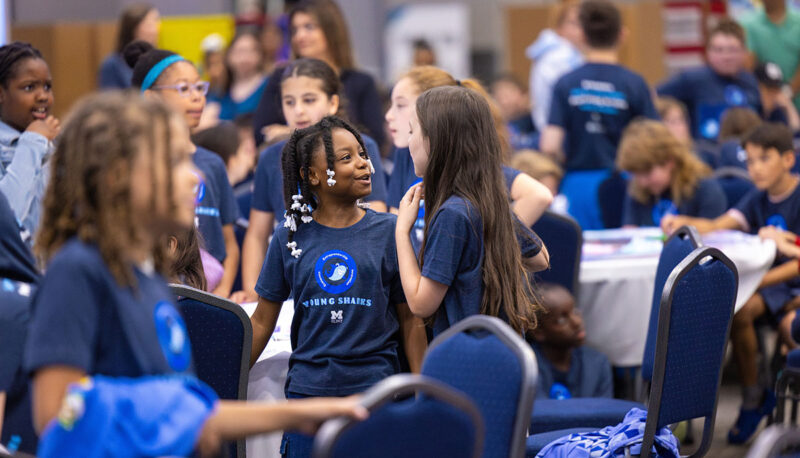 A group of Young Sharks competitors speaking in the crowd.