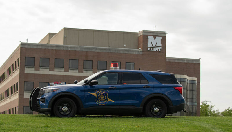 A Michigan State Police vehicle parked in front of the UM-Flint White Building