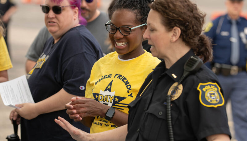 An Officer Friendly Day volunteer laughing with UM-Flint DPS Sergeant Heather Bromley