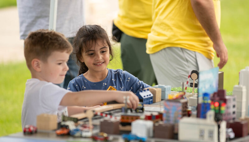 Two young attendees playing with the model city