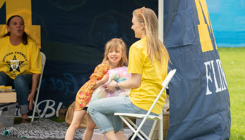 An Officer Friendly Day attendee laughing with a volunteer