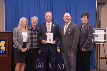 Steve Whitener posing with an award on stage.