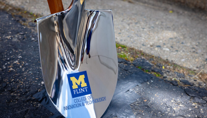 A shovel with the UM-Flint CIT logo