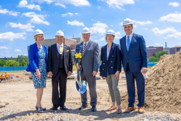 A group in hard hats holding the ceremonial shovel. From Left to Right: Donna Fry, Sheldon Neeley, Chris Pearson, Kimberly Roberson, Mike Behm