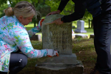 Two women cleaning a tombstone