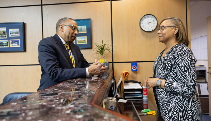 Chancellor Alexander speaking with a staff member.