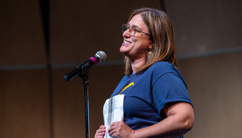 Gabriela Histrova speaking at a microphone on stage.