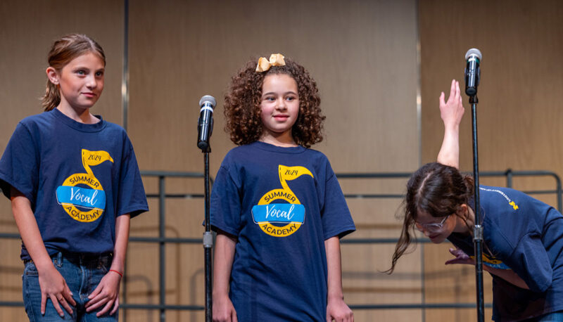 A singer takes a bow while others smile