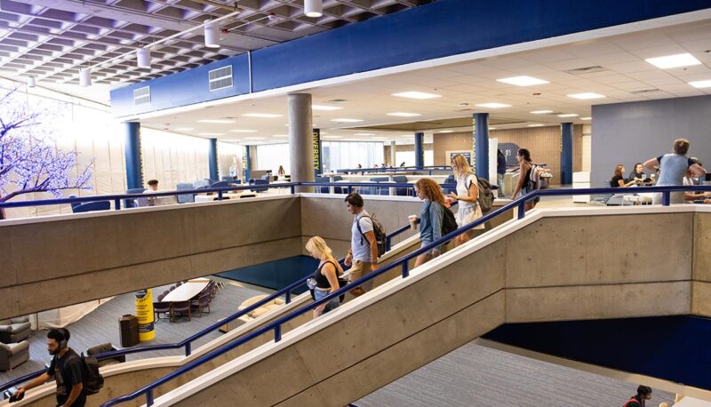 Students walking down the 3rd floor steps of UCEN.