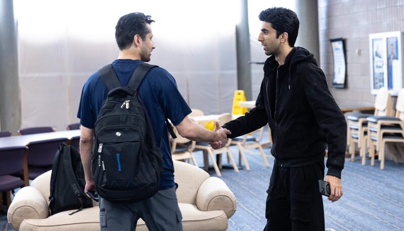 Two students shaking hands in UCEN.