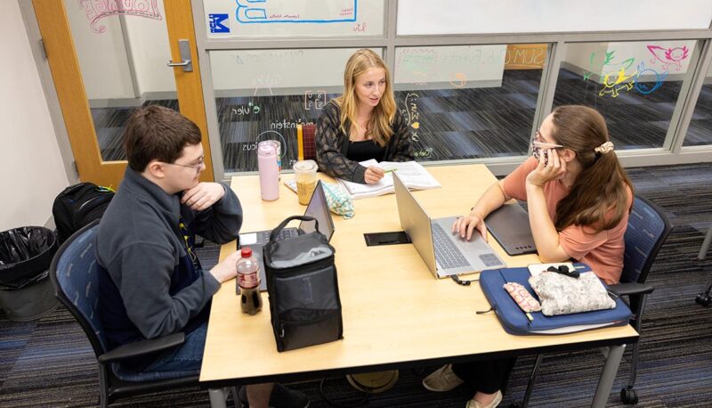 Three students working a table.