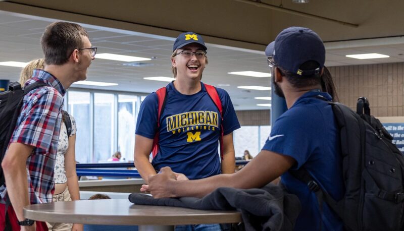 A group of students standing around a table in the UCEN.