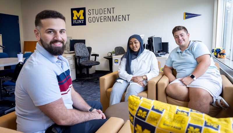 Students smiling for the camera in the Student Government office.