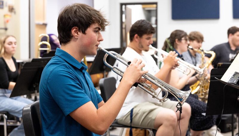 Students playing musical instruments in a classroom.