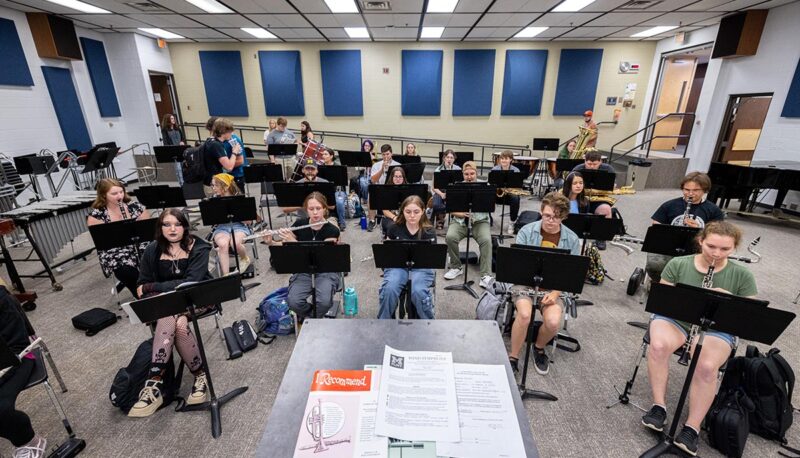 Students playing musical instruments in a classroom.