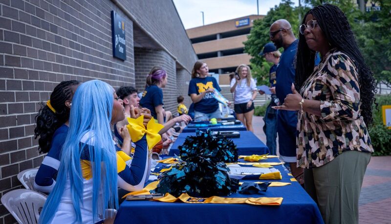 UM-Flint staff members at tables speaking with R'Extravaganza attendees.