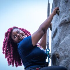 A student climbing a rock wall.