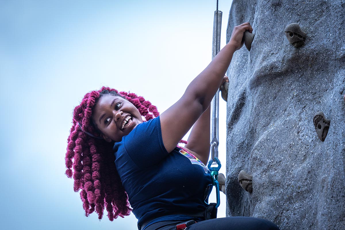 A student climbing a rock wall.