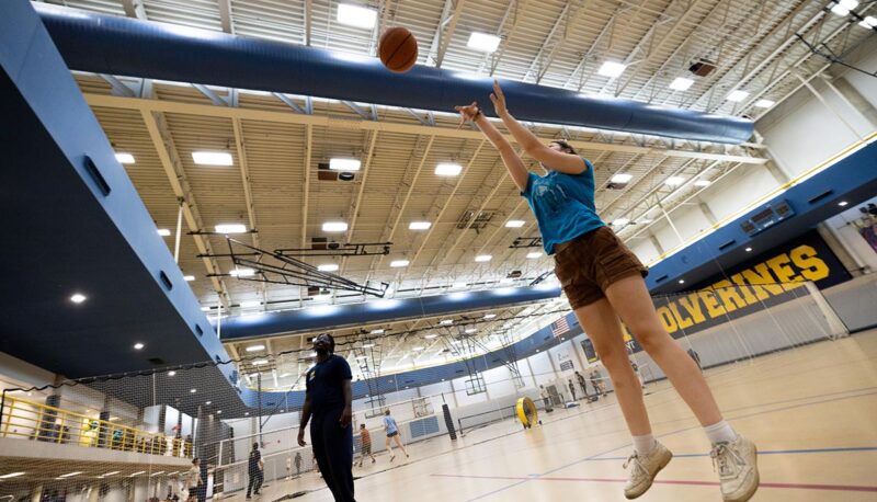 A student shooting a basketball in the Rec Center.