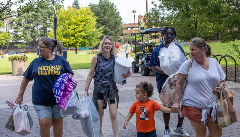 A family carrying items into First Street Residence Hall