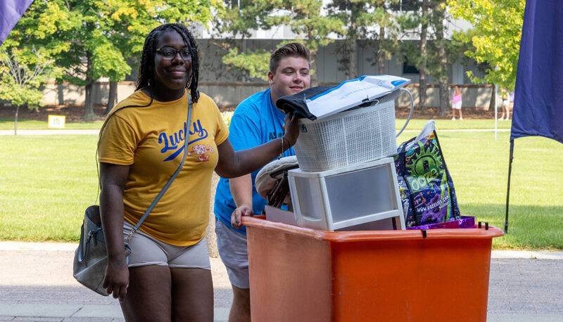 A bin filled with dorm items being pushed into First Street Residence Hall.