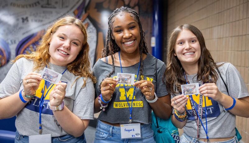 Three students smiling for the camera