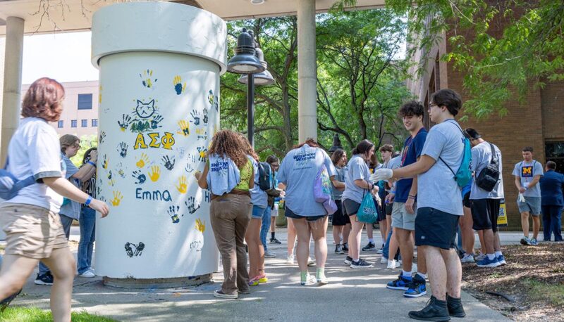 Students painting the pillar between the University Center and French Hall