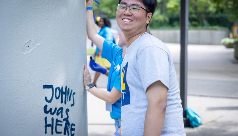 Students painting the pillar between the University Center and French Hall