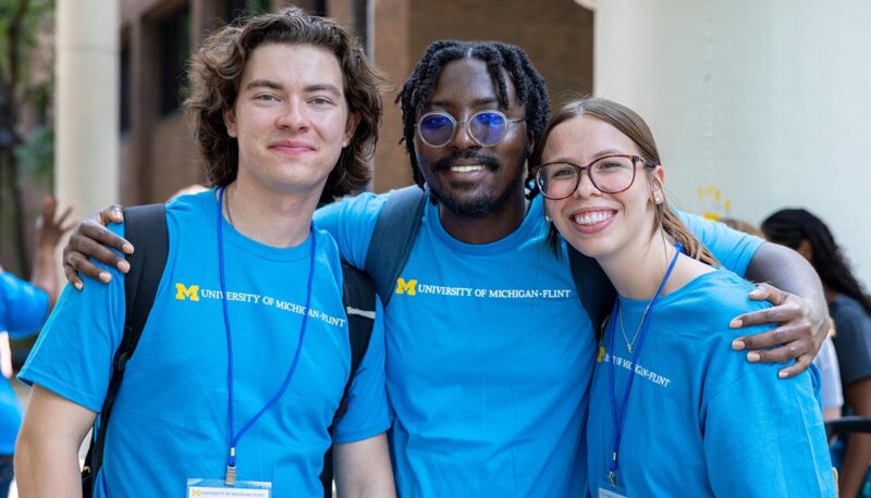 Three students smiling for a photo.