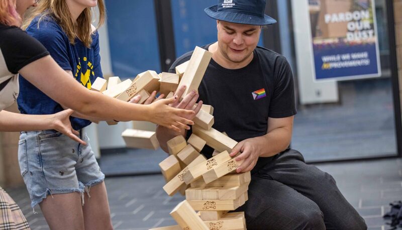 Students playing Jenga. The tower is collapsing.