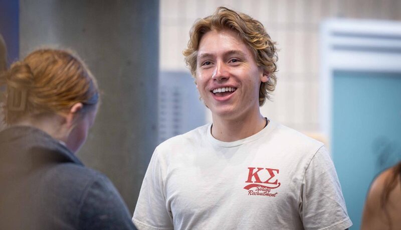 A student snukung wearing a Kappa sigma t shirt.