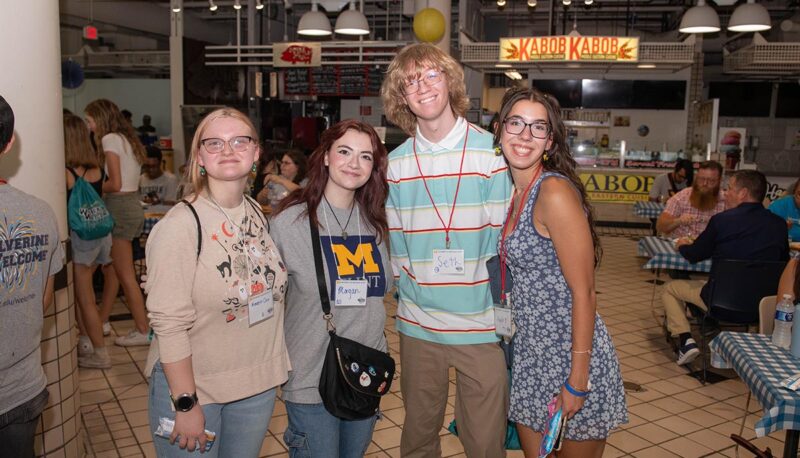 A group of students smiling for the camera inside the University Pavilion.