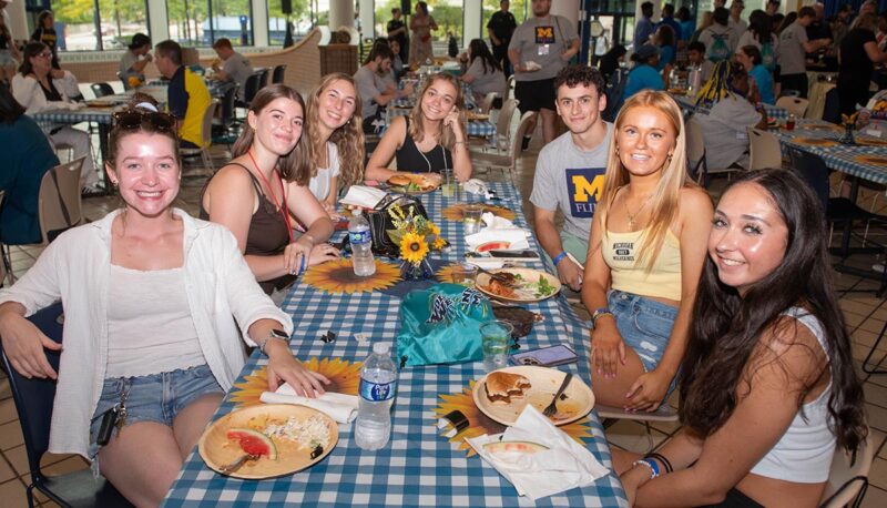 A table of students with food smiling for the camera.