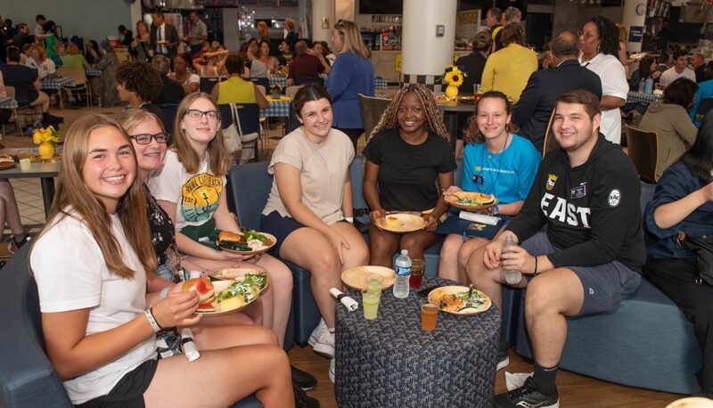 A table of students with food smiling for the camera.