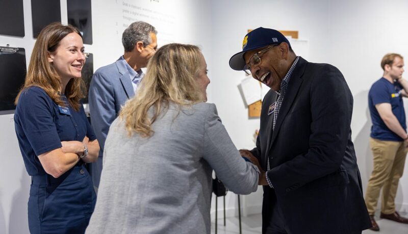 Chancellor Laurence Alexander laughing and shaking hands.