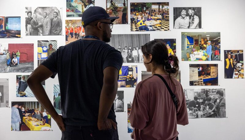 Gallery visitors viewing art on the walls.