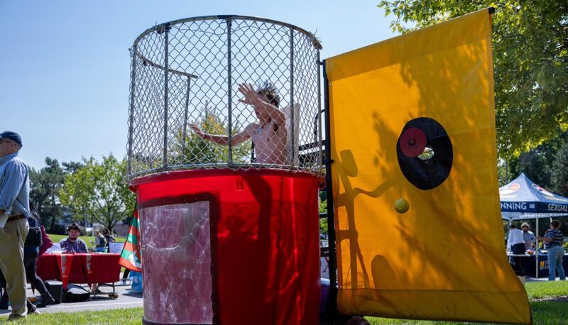 A student sitting and waiting to be dunked in a dunk tank.