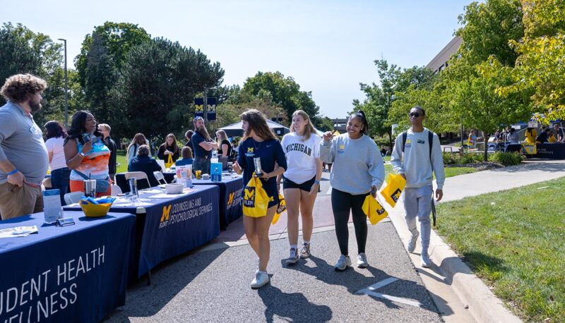 Students walking down the row of tables during the MGagement Fair.