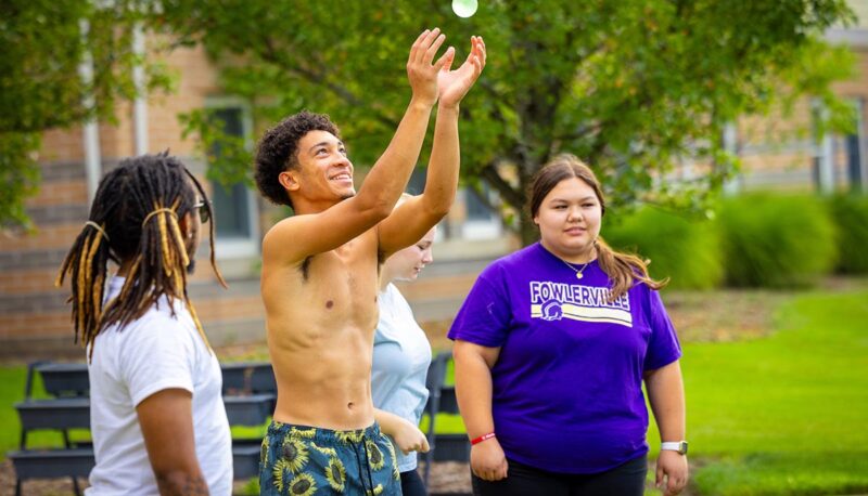 A group of students catching a water balloon