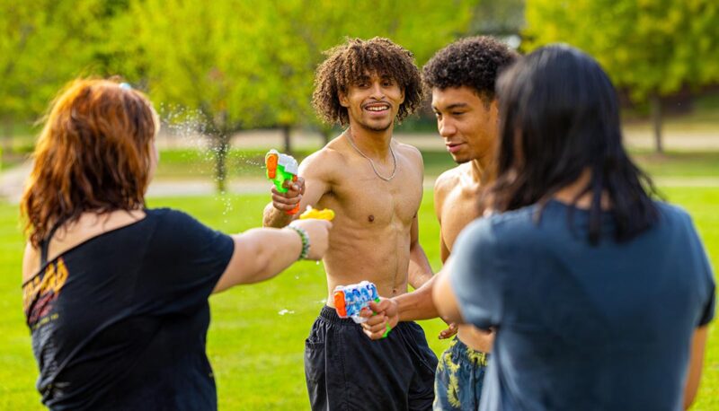 A group of students squirting each other with water guns