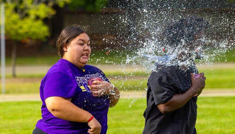 Students throwing water balloons at each other.