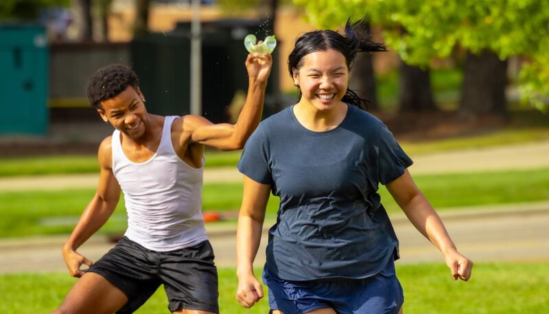 Students throwing water balloons at each other.