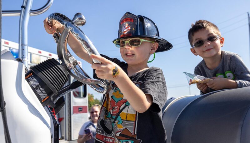 A young child in a cockpit of a boat.