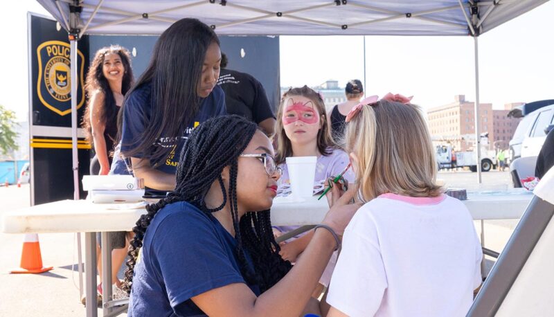 A young child getting face painted.