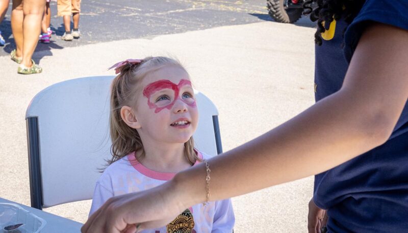 A young child getting face painted.