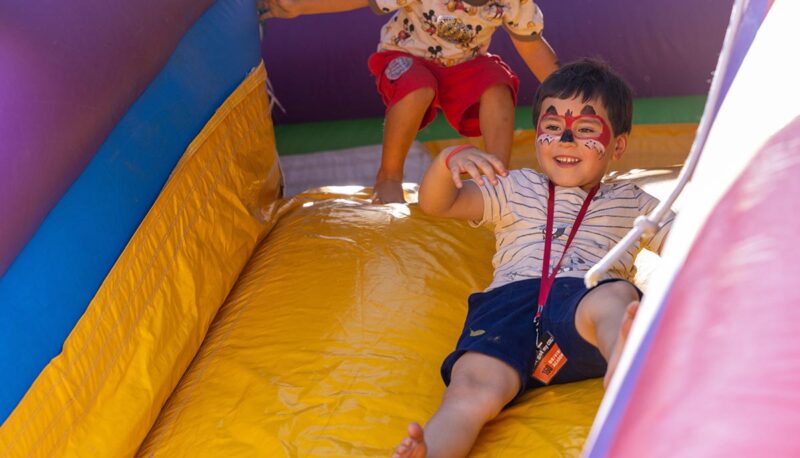 A young child sliding down an inflatable slide